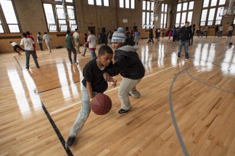 Children play basketball in a gym